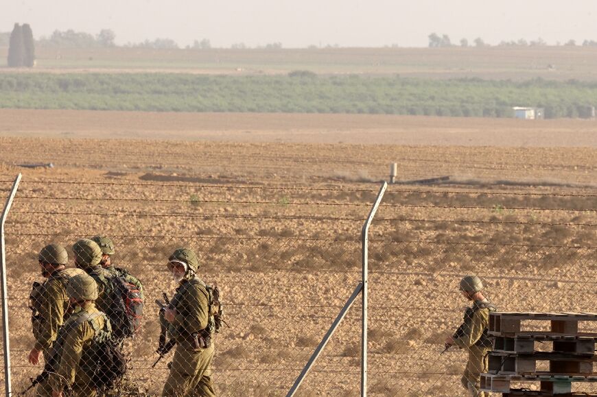 Israeli soldiers patrol near the fence of kibbutz Nir Oz in southern Israel, on November 9, 2023