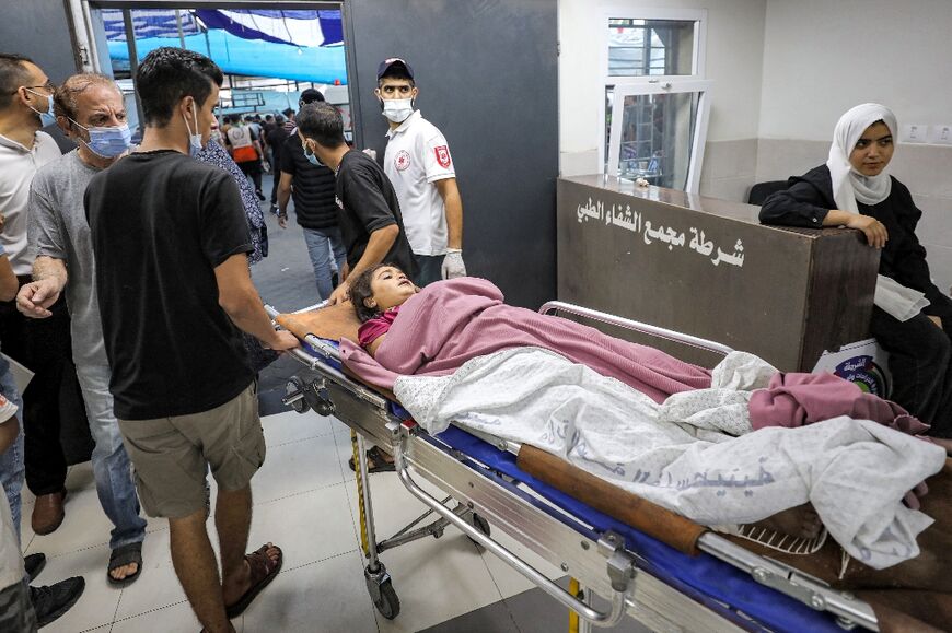 A young victim who was injured in Israeli bombardment is transported on a gurney at Al-Shifa hopsital in Gaza City 