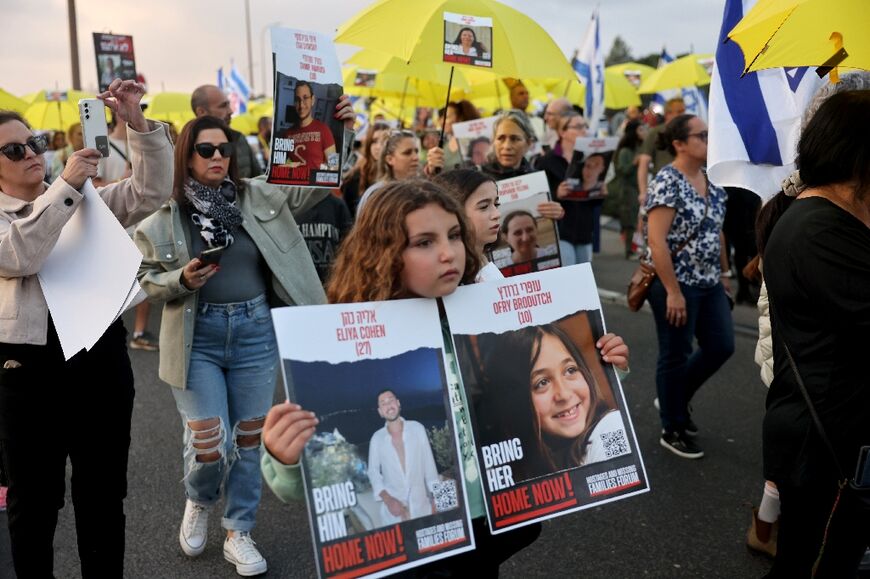 A girl carries posters of Israelis feared held by Hamas in Gaza during a march on Jerusalem calling for their release