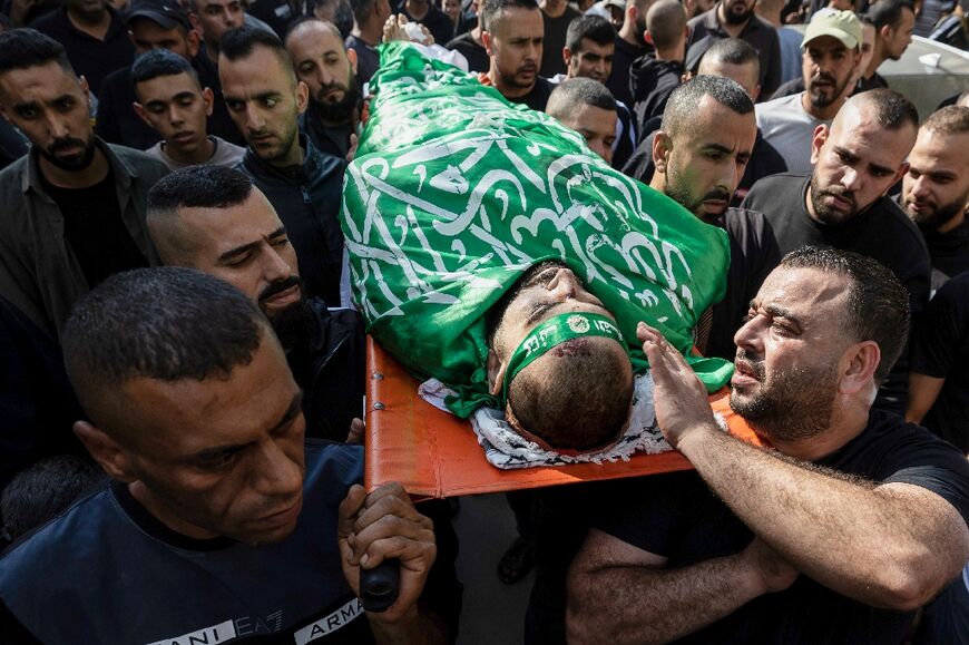 Mourners carry the body of a man draped with the Hamas flag after an Israeli army raid on the Jenin refugee camp