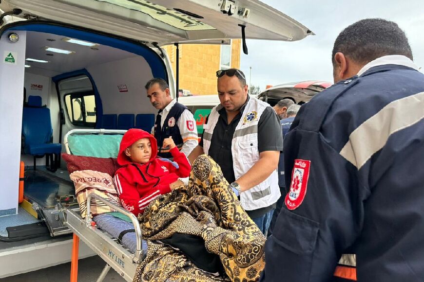 Egyptian paramedics transport an injured Palestinian child to a Red Crescent ambulance upon his arrival from Gaza via the Rafah border crossing 