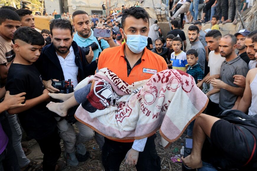 A Gazan carries the covered body of a child killed in bombardment of Khan Yunis on November 4