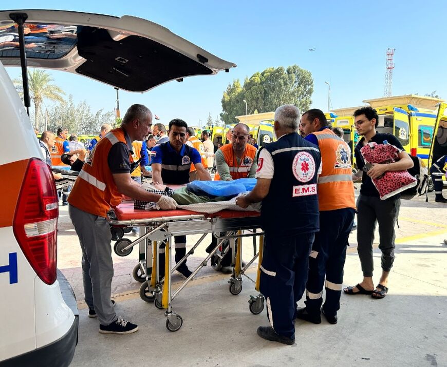 Egyptian paramedics transfer an injured Palestinian woman on the Egyptian side of the Rafah border crossing with the Gaza Strip, in the north eastern Sinai province, on November 7, 2023 amid ongoing battles between Israel and Hamas