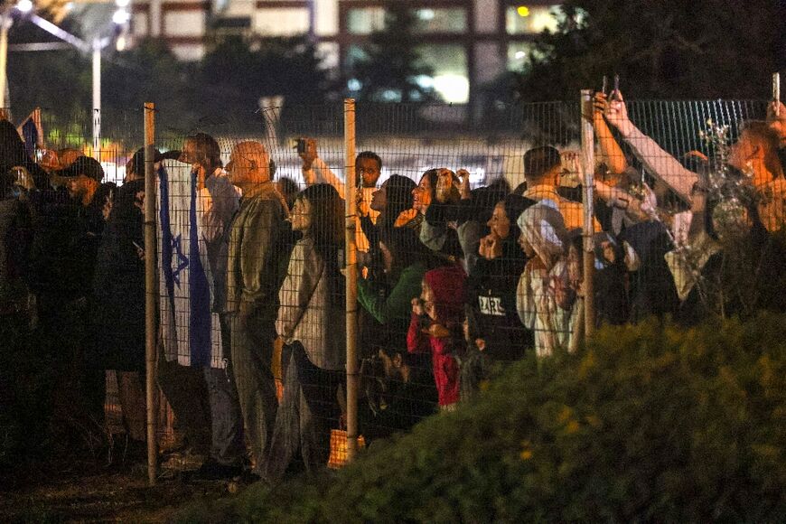 Israelis look on as a helicopter with released hostages prepares to land at Tel Aviv's Schneider medical centre