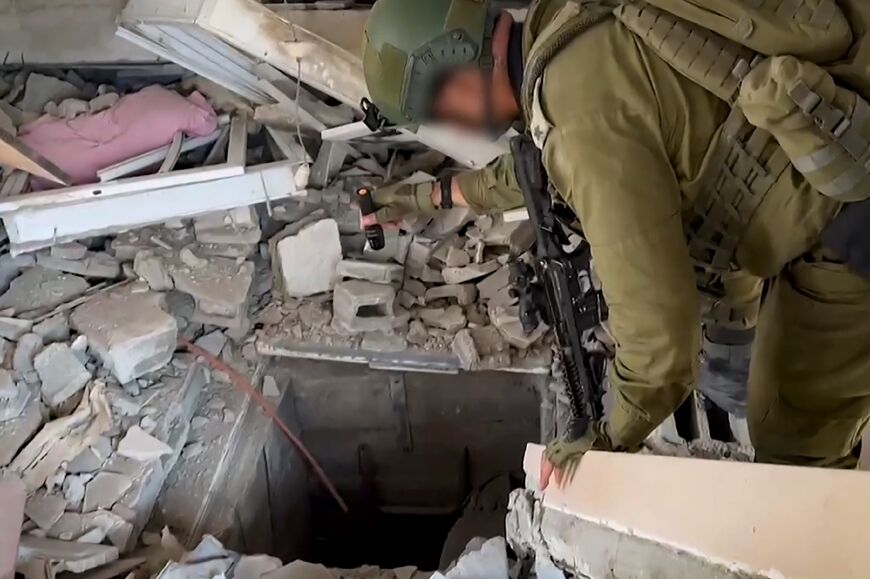 This screen grab taken from a handout footage released by the Israeli army on November 3 shows a soldier checking what it says is the entrance to a Hamas tunnel in Gaza