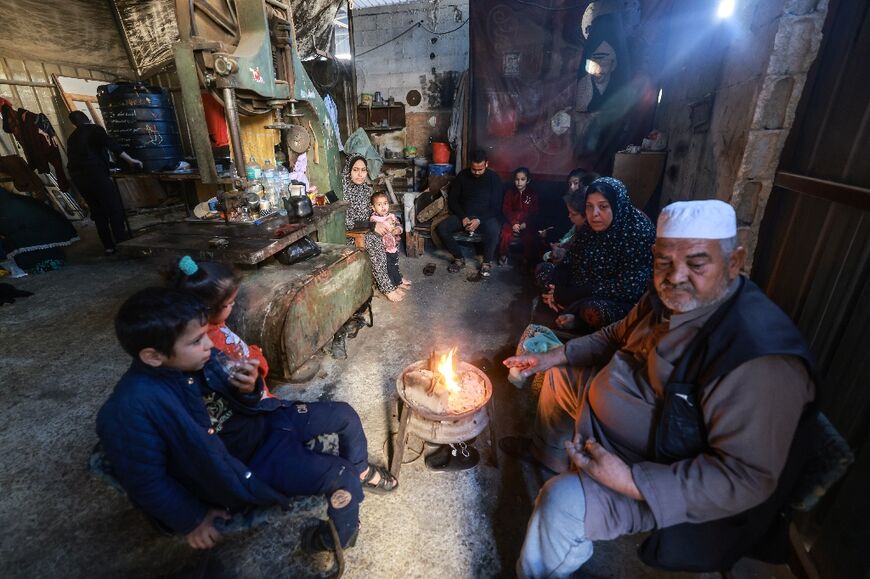 A Palestinian family who fled from Gaza City to Khan Yunis and then to Rafah, in the southern Gaza Strip, found temporary shelter inside a workshop 