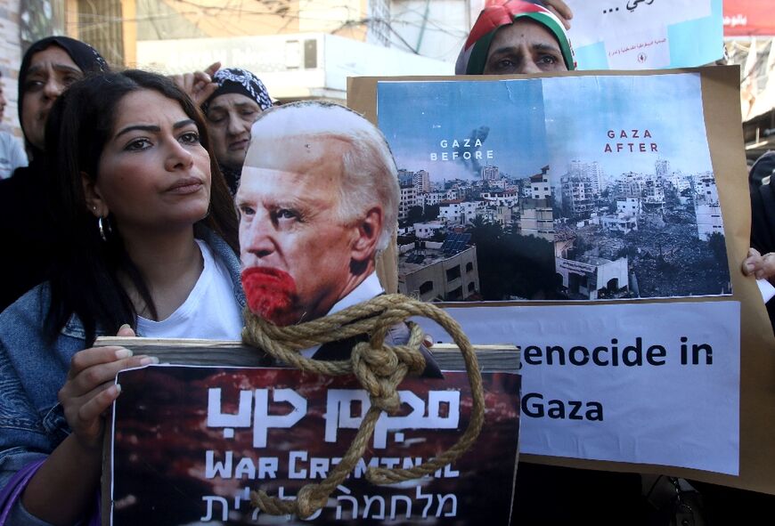 A woman holds up the image of US President Joe Biden with a rope around his neck during a protest in the Ain al-Hilweh Palestinian refugee camp near the southern Lebanese port city of Sidon on October 18, 2023