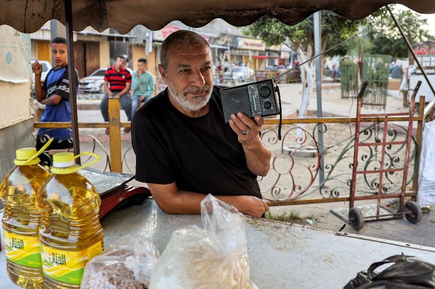 A man listens to a radio broadcast on a street in Rafah 