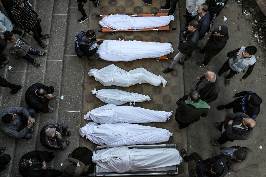 Mourners stand by shrouded bodies of relatives at Khan Yunis's Nasser hospital