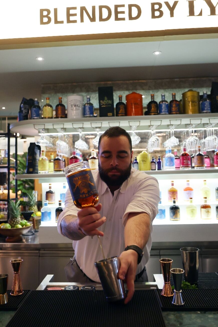 Lebanese bartender Hadi Ghassan prepares a drink behind the counter at a pop-up bar offering non-alcoholic bellinis and spritzes
