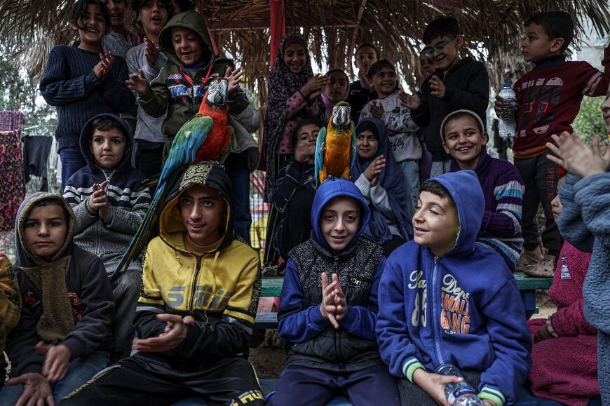 Displaced Palestinian children sheltering at Rafah zoo get acquainted with its resident parrots