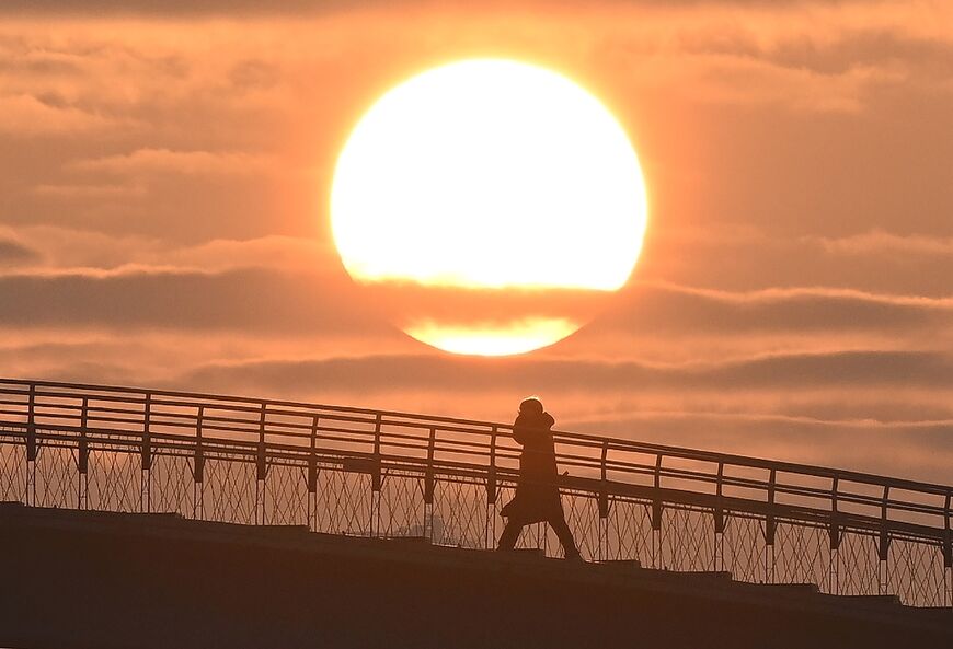 A person crosses a footbridge at the first sunrise of the new year in Seoul