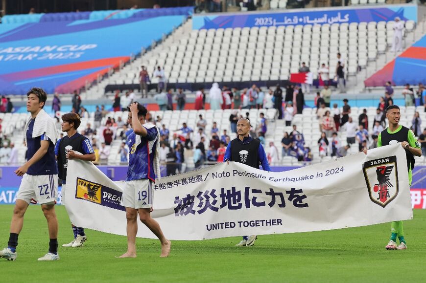 Japan's players greet their supporters after beating Bahrain