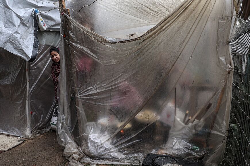 Displaced Palestinians shelter under palstic sheeting in Rafah in the southern Gaza Strip on January 2, 2024