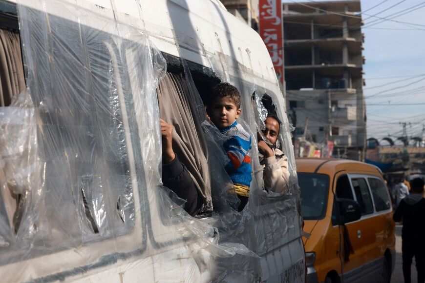 Palestinians look out from a minibus at a market in Rafah refugee camp, south Gaza