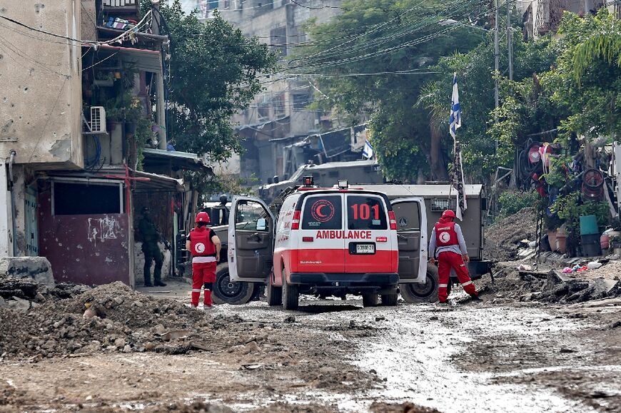 Palestinian medics stand outside a Red Crescent ambulance during an Israeli army operation in the occupied West bank