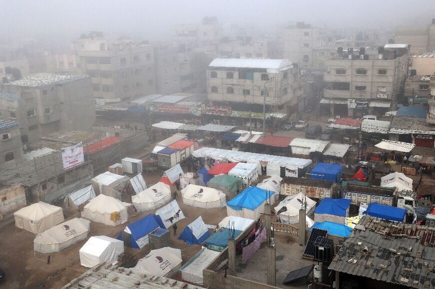 Fog covers buildings and tents set up by displaced Palestinians in Rafah in the southern Gaza Strip on February 25, 2024
