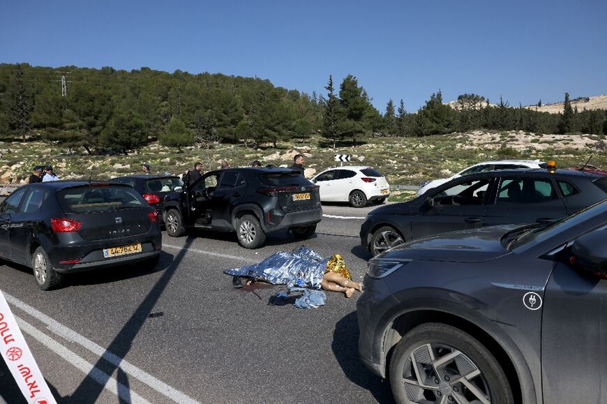 A body lies on the road near Maale Adumim Jewish settlement, east of Jerusalem, after a shooting attack that killed one person, wounded eight and left three attackers 'neutralised', Israeli police said