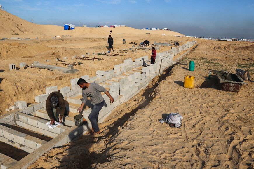 Palestinians in Rafah were digging new graves in the sand near a makeshift camp 