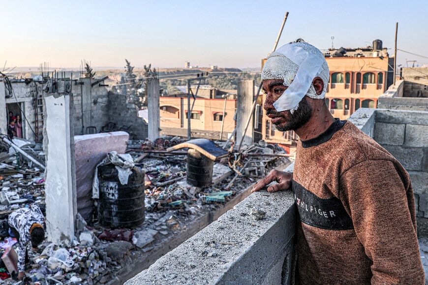 An injured man looks at the rubble of a destroyed building in the aftermath of Israeli bombardment on Rafah in the southern Gaza Strip on February 7, 2024