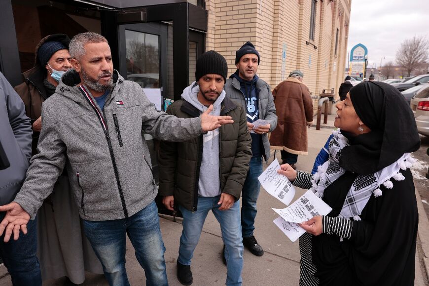 Samra'a Luqman (R) hands out fliers outside of the American Moslem Society Mosque to ask voters not to vote for President Joe Biden after Friday prayers in Dearborn Heights, Michigan on February 16, 2024