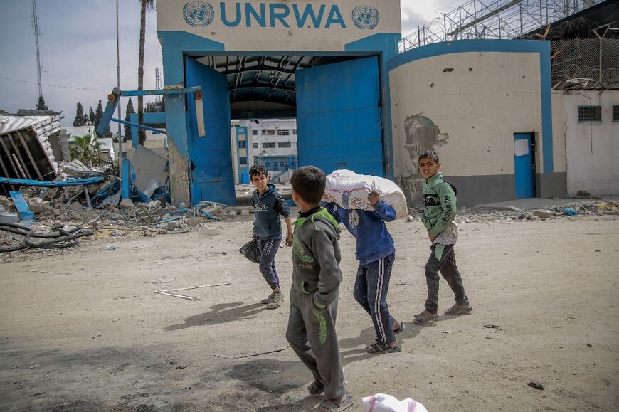 Children carry bags of flour after humanitarian aid was distributed in Gaza City on March 17, 2024