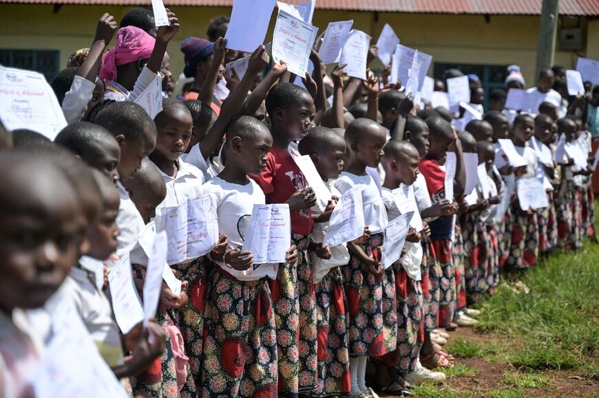 Kenyan girls hold certificates upon completion of the alternative rite of passage ceremony organised by Manga HEART, a non-profit fighting gender-based violence and female genital mutilation (FGM) in Kisii