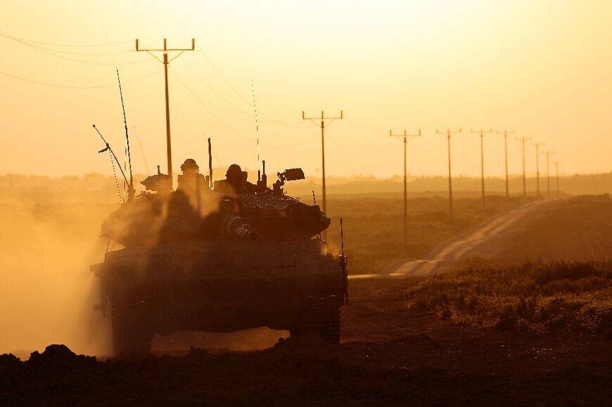 Seen from Israel, an Israeli army tank moves along the border with the Gaza Strip
