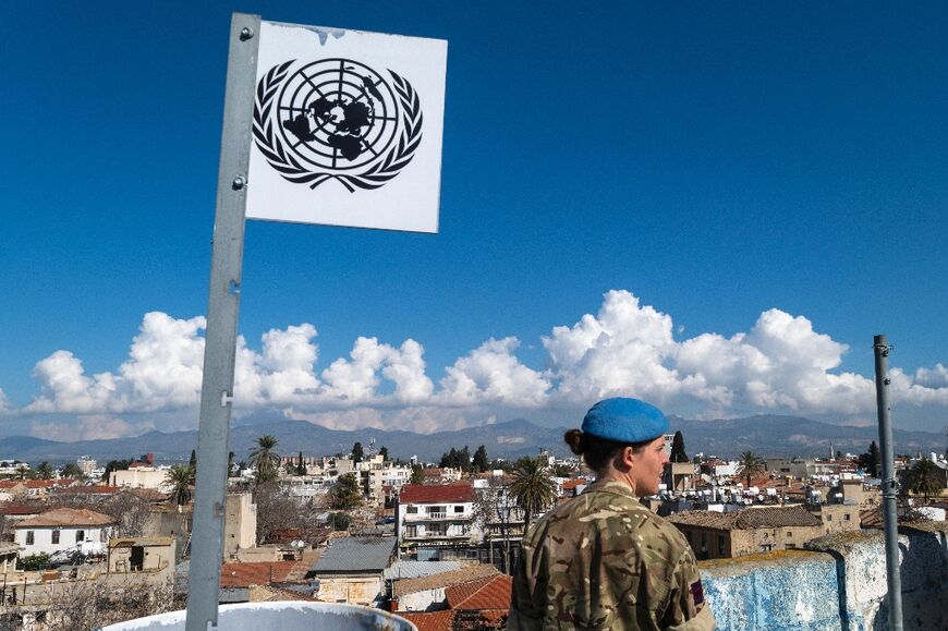 A UN peacekeeper keeps watch from a rooftop of an abandoned building overlooking the buffer zone in divided Nicosia