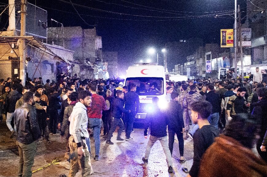 People gather around an ambulance at the scene of a bomb explosion in the northern Syrian city of Azaz, early on March 31, 2024