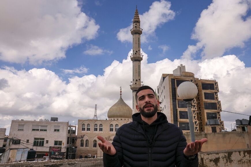 Palestinian widower Bahaa Al-Masalmeh in front of a mosque in the town of Dura