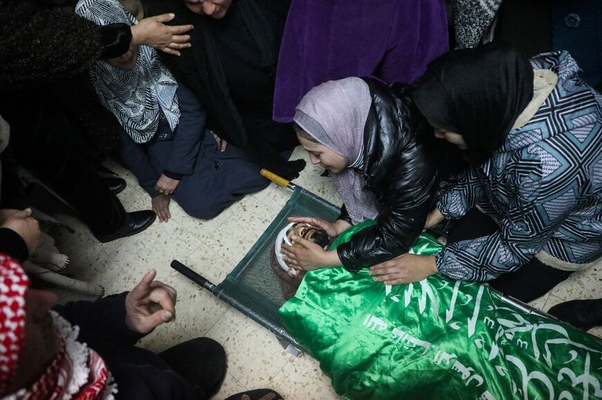 Relatives mourn Palestinian Moataz Atbeish, who died of wounds following an Israeli raid, in Dura, on January 29, 2024