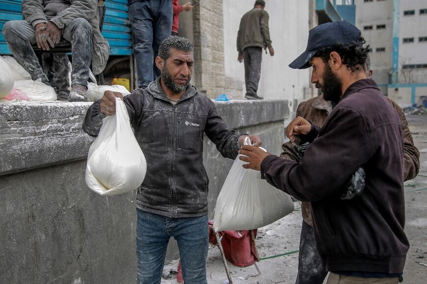 A Palestinian man receives a bag of flour at a Gaza City distribution centre