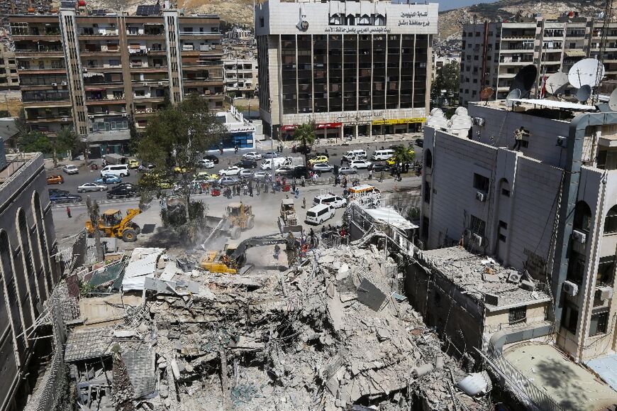 Rescue workers search in the rubble of a building annexed to the Iranian embassy in Damascus 