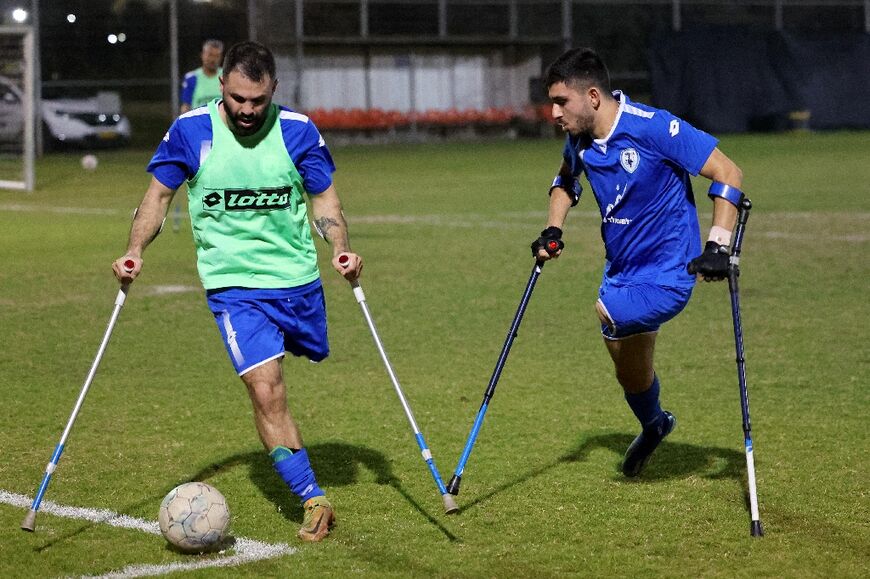 Striker Ben Maman (R) challenges a teammate as the Israeli national amputee football team train near Tel Aviv