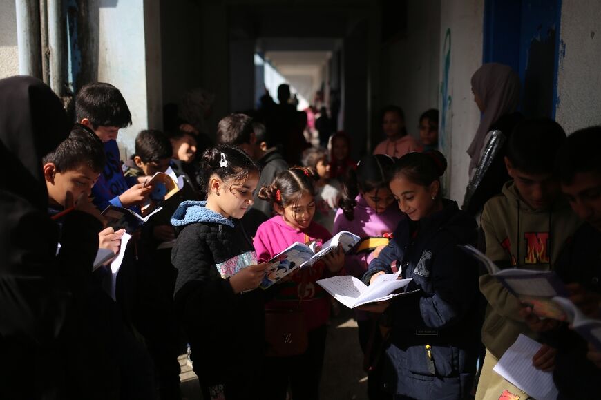 Displaced children in Rafah, Gaza, learn English in the corridor of a school where are also now living 