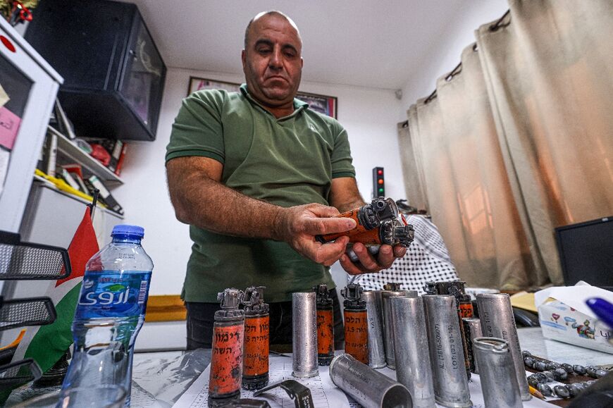 Palestinian high school vice-principal Mazin Shehadeh displays stun grenades and tear gas canisters at his school