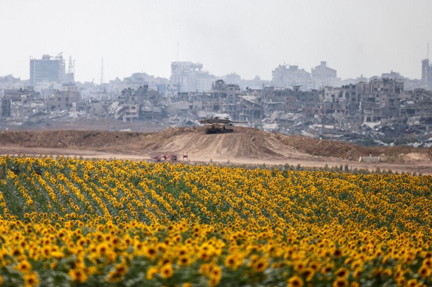 An Israeli army tank deploys near a sunflower field in Israel's southern border with the Gaza Strip