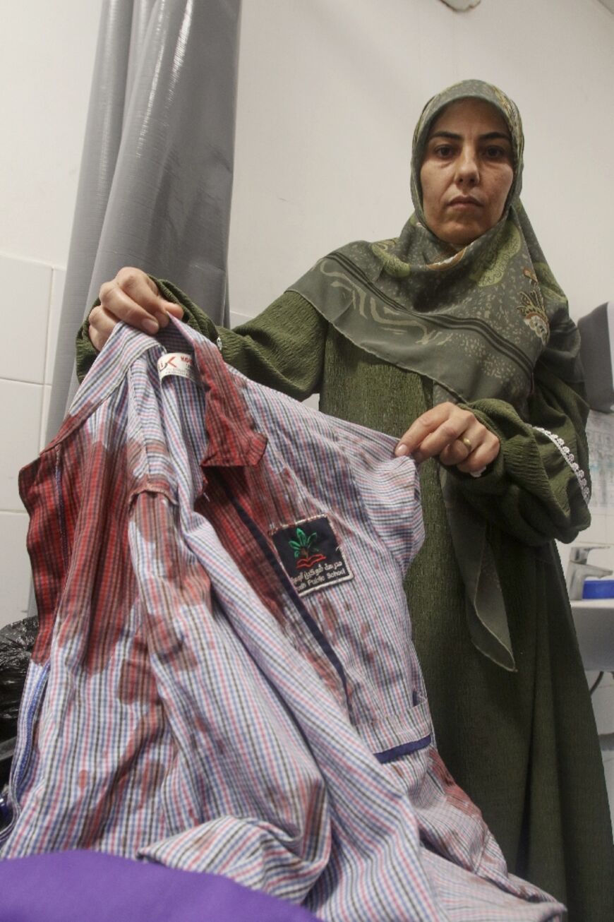 The aunt of 11-year-old Lebanese school boy Mohammad Ali Nasser shows his shirt covered with blood 