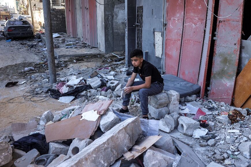 A boy sits amid rubble at the site of a building that was hit by Israeli bombardment in Rafah