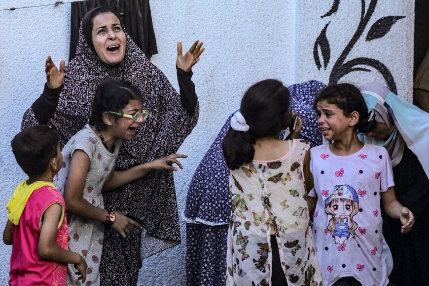 Palestinians react to an Israeli strike on a building in Nuseirat on May 25, 2024