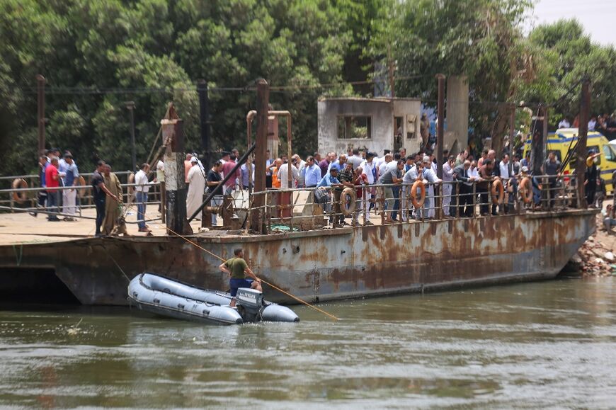 Relatives wait on the bank of a canal of the Nile River as rescuers search the waterway for casualties after a minibus sank near Abu Ghalib village in Egypt's Giza governorate