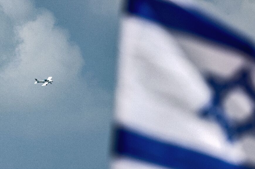 An ultralight aircraft displaying on its tail fin pictures of hostages still held captive in the Gaza Strip flies over Israel's Netanya city to mark the country's 76th Independence Day 