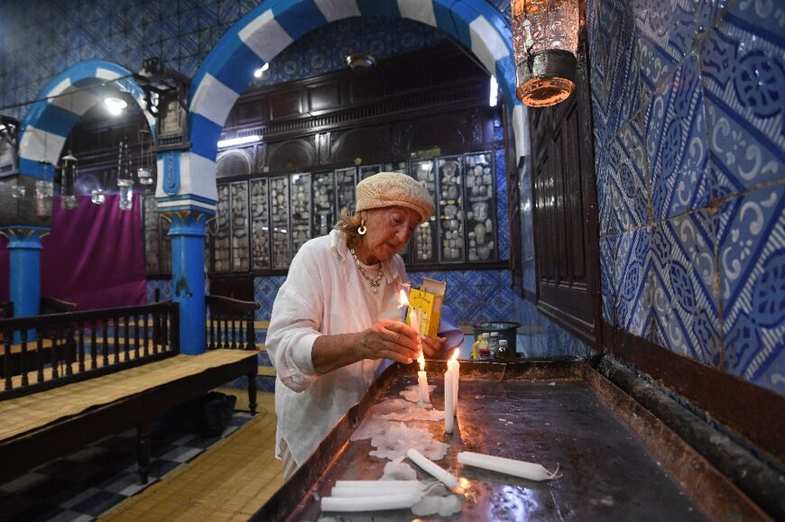 A pilgrim lights a candle inside the Ghriba synagogue