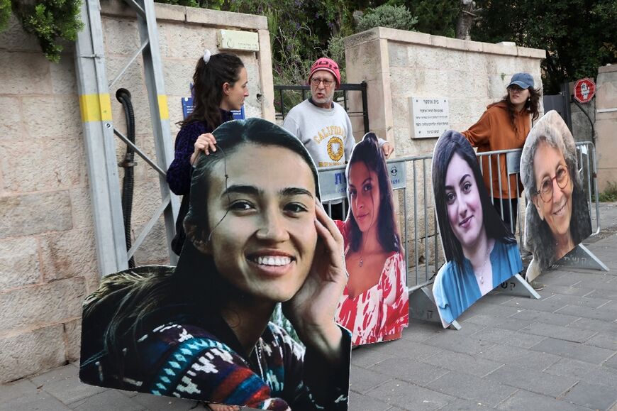 Relatives and supporters set up cardboard cutout portraits of Israeli women held hostage in Gaza outside Prime Minister Benjamin Netanyahu's Jerusalem residence 