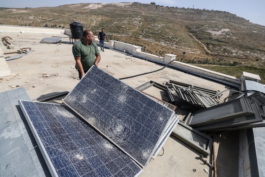 Mazin Shehadeh displays the damages to solar panels at his school from an attack byIsraeli settlers