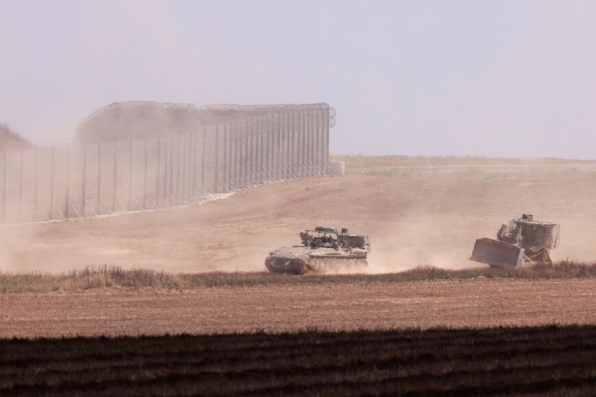 Israeli military vehicles roll near the border with the Gaza Strip