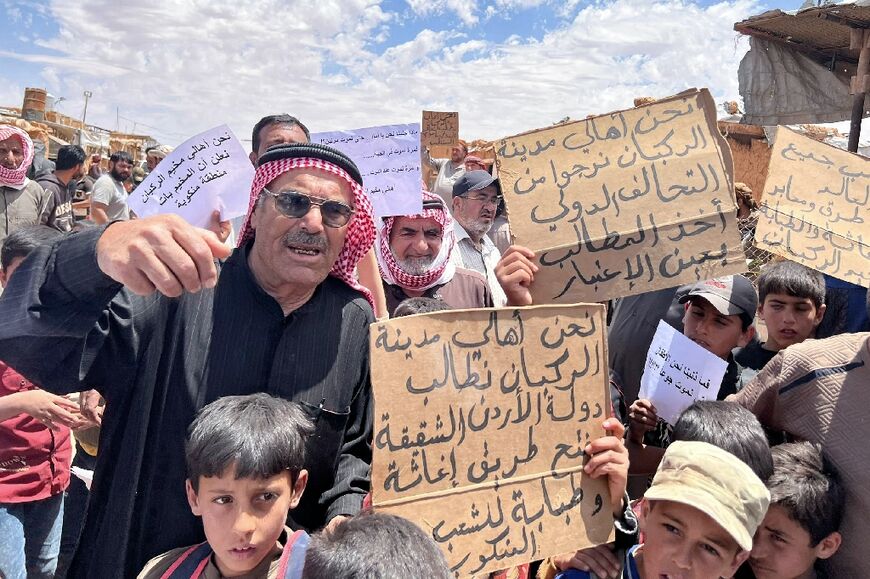 Around 8,000 people remain at the camp, some of whom are shown protesting for outside help in this picture provided by the Syrian Emergency Task Force