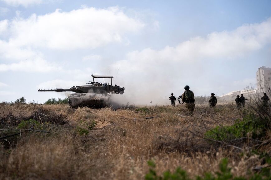 Israeli soldiers walking next to tank in the Zeitun area of Gaza City