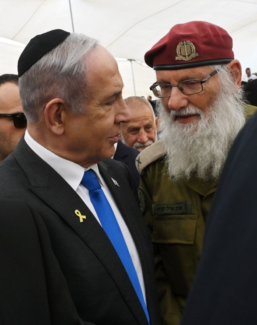 Israeli Prime Minister Benjamin Netanyahu speaks to a veteran on the eve of Memorial Day